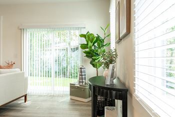 a living room with a large window and a small table with a plant on it at Beckington, Leland, NC, 28451